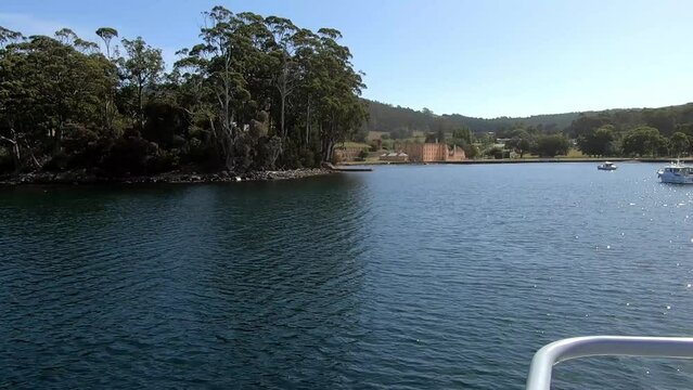 Arriving At The Port Arthur Historic Site Via A Tourist Boat With The Old Buildings Of The Penal Settlement In The Background