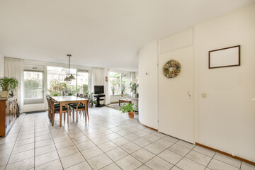 a living room with tile flooring and large sliding door leading to the dining area in the room is...