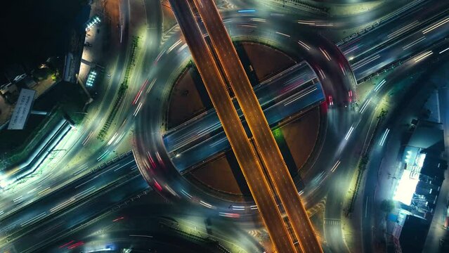 Hyperlapse time-lapse of car traffic transportation above circle roundabout road in Asian city. Drone aerial view fly in circle, high angle. Public transport or commuter city life concept	
