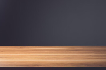 Top space of wooden desk. Brown wooden table top on dark grey wall background. For Mockup or product advertising display