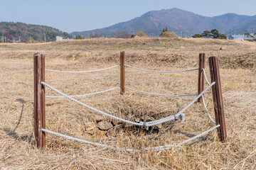 Water well cordoned off with wooden beams and rope at remains of stone fortress in Yeosu, South Korea.