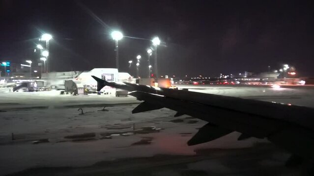 Stockholm, Sweden A plane taxiing on the snowy runway before take-off at night. 
