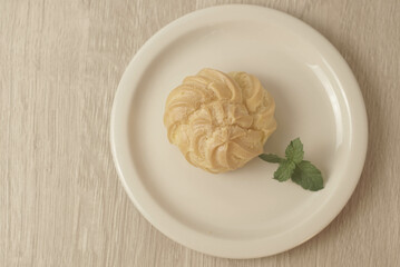 Kue Soes or choux à la crème on white plate. Perfectly puffed and filled with a creamy filling, this classic French dessert is sure to delight. Selective Focus , Closeup