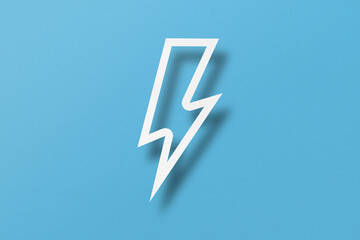 Paper cut lightning shape, lightning with light and shadow. Placed on a light blue paper background.