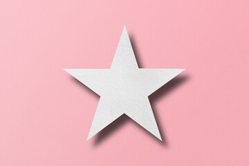 paper cut star shape with light and shadow Placed on a pink paper background.