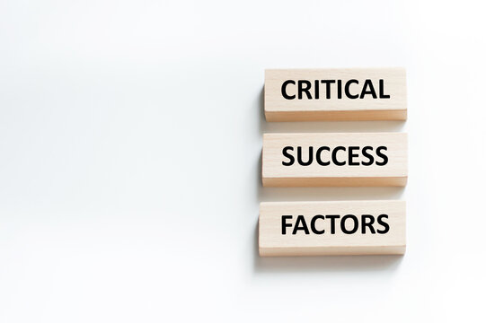CRITICAL SUCCESS FACTORS - words on wooden blocks on gray background. Business and hybrid working culture concept, copy space.