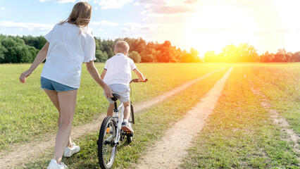 mom teaches her son to ride a bike