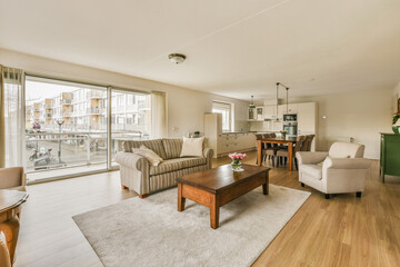 a living room with couches, chairs and a coffee table in front of a sliding glass door looking out...