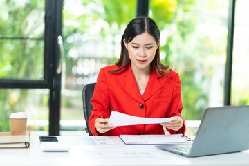 Obraz premium Portrait of pretty cheerful girl smiling while working on laptop in office