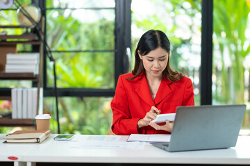 Portrait of pretty cheerful girl smiling while working on laptop in office