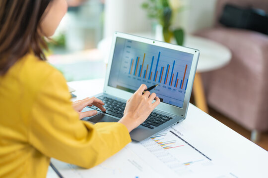 business woman using laptop or notebook computer with data analysis graph dashboard, confident woman working with computer laptop concept, contact idea design dashboard graph business conceptual.