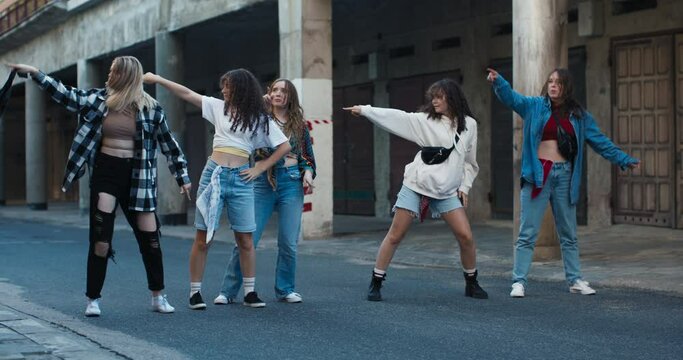Youth concept performers schoolgirls dancing freestyle hiphop actions movements rehearsal time outside on street girls having fun spending time funny preforming time .