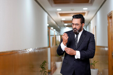 Confident businessman buttoning or adjust classic suit at office