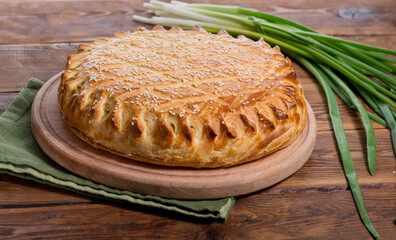 savory pie with a filling on a wooden background