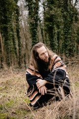 portrait of a man with long hair in the woods