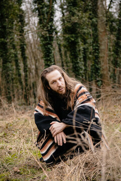 portrait of a man with long hair in the woods