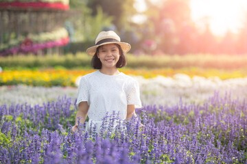 Beautiful woman enjoying flowers field, nice female lying down in meadow of flowers, pretty girl relaxing outdoor, having fun, happy young lady and spring green nature, Freedom concept.