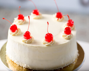 White cake decorated with red cherries