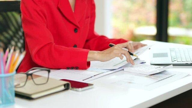 Portrait of asian business woman paying bills online with laptop in office. Beautiful girl with computer and checkbook, happy paying bills. Startup business financial calculate account concept