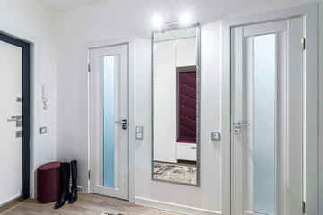 Modern hallway in an apartment with women's boots standing near the door