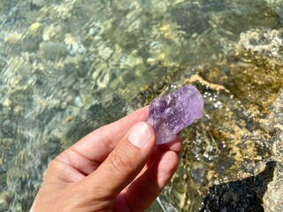 Hand holding purple amethyst crystal bolivianit stone.