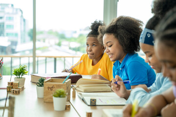 Black girl in classroom with diverse group of children learning new stuff,In elementary school class.