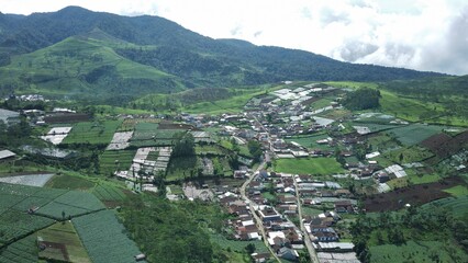 Aerial imagery of a hidden village above the clouds located near a mountain.
