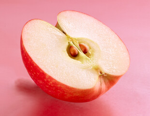 Halber Apfel Pink Lady auf rosanem Fond