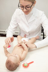 Obraz na płótnie Canvas Female masseur doing baby massage for foot little infant baby child