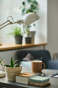 Vertical image of workplace with hot drink on table during coffee break at home
