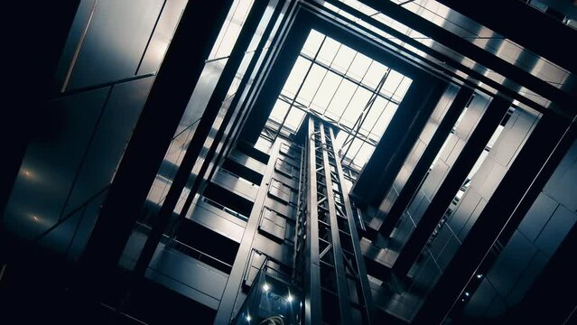 Bottom-up view of interior of a modern office. Black walls, elevator, panoramic roof