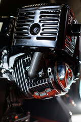 Black motorcycle carburetor on engine