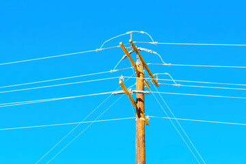 Close-Up of Wooden Power Pole and Wires Against Blue Sky