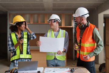 Architect team working with blueprints for architectural plan, engineer sketching a construction project, green energy concept