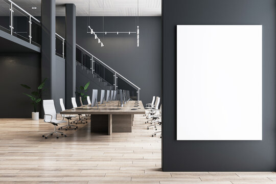 Front view on blank white poster on dark wall with place for your logo or text in loft style spacious office hall with conference table, wooden floor and dark wall background. 3D rendering, mock up