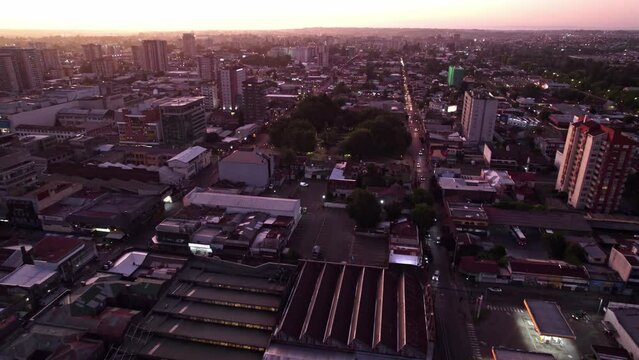 Dolly in aerial view of a blue hour with purple color, with traffic on the streets, cars with lights flashing. Temuco, Chile
