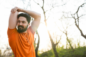A handsome young man is working out in the park