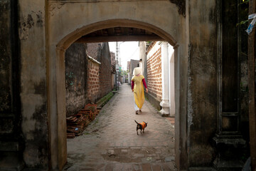 A charming Vietnamese woman in traditional ao dai dress in the ancient village of Duong Lam, Son Tay district, Hanoi. VN