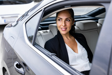 A beautiful business woman is driving in the car