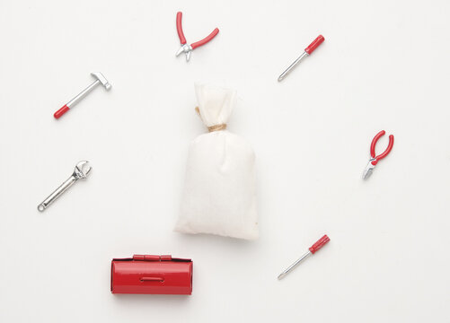 A flatlay picture of money bag and tools miniature on isolated white background.  Fix your bank account concept.