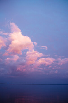 Pink clouds and blue sky at sunset with reflection on lake