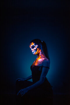 Girl's face painted UV skull