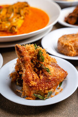 Ayam Goreng Padang. Traditional fried chicken with spice crumbs from Minangkabau, West Sumatra. served on white plate 