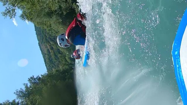People riverboarding, or hydrospeeding down Isere, France river. Vertical slow motion.
