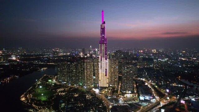 wide aerial zoom in of the Saigon skyline with Landmark 81 building lit up in a modern asian city