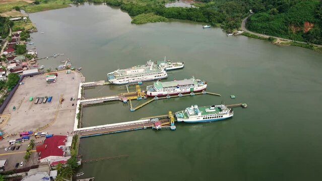 Public passenger ferries parked at the port of Poto Tano Harbour Sumbawa Indonesia. Logistic industry, freight transportation business concept. 4K aerial
