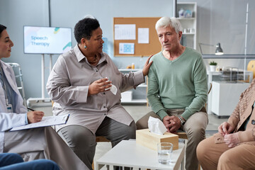 Portrait of senior white haired man sharing feelings in mental health support group at retirement...