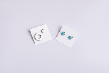 Handmade round earrings on white cardboards. Horizontal. Packaging for earrings