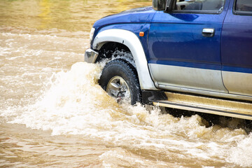 Muddy rain from a heavy rainy season flooded main roads connecting the district, making it difficult for cars to pass through and causing engine failures, in motion, car insurance concept.