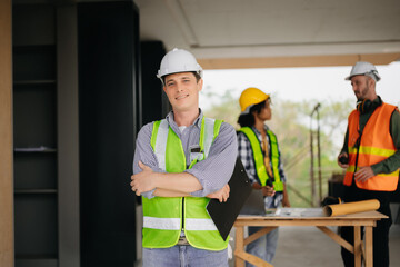 Contractor and architect looking at plan, tablet, laptop and talking about working on big project. Building in construction process interior. team work .